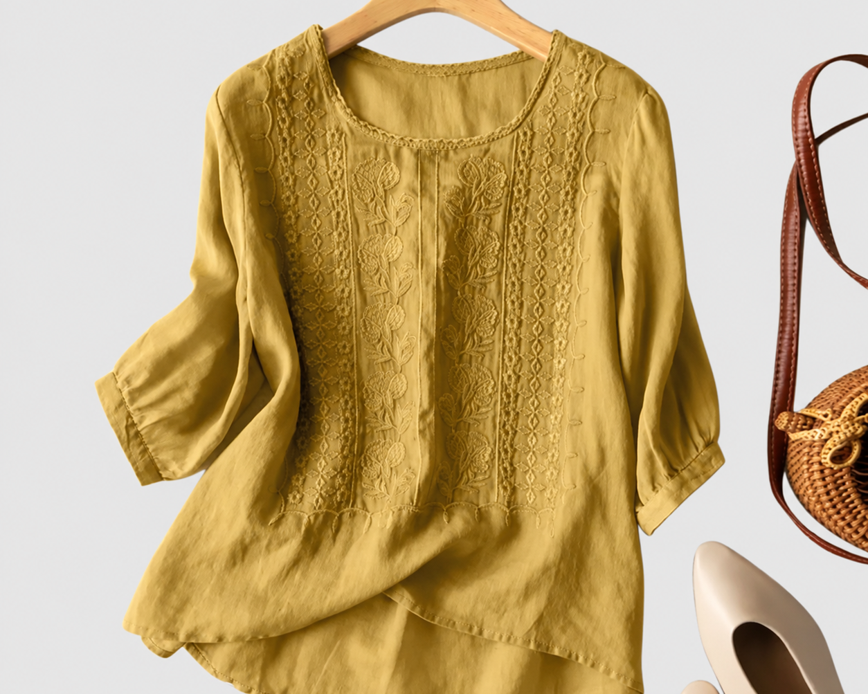 Aurora yellow embroidered blouse on a neutral grey background