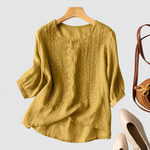 Aurora yellow embroidered blouse on a neutral grey background