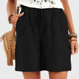 Black drawstring shorts on a neutral grey background