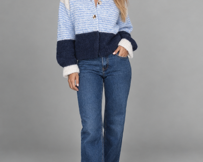 Cream, light blue and navy button cardigan photographed against a grey studio background.