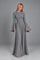 Dua York model wearing the grey Selene floor-length dress with bell sleeves against a grey studio background